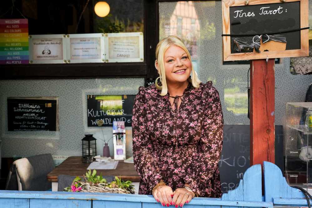 Tine Wittler steht in einer Cafe Kulisse