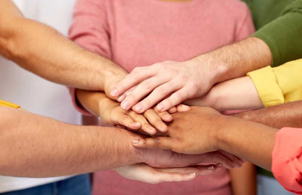 Gruppe von Menschen hält die Hände Zusammen