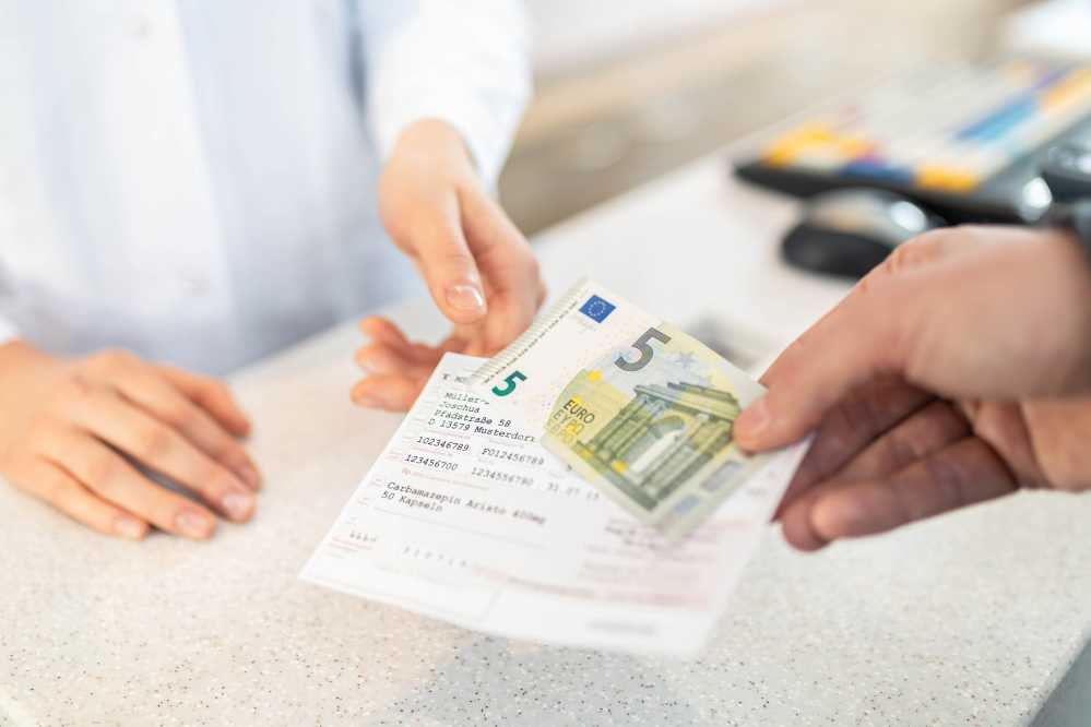 Rezept und fünf Euroschein werden überreicht.