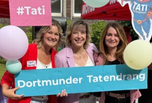 Das Team von Tatendrang hält ein Banner und Ballons