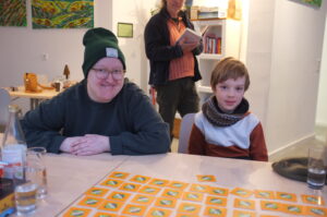 Eine Frau und ein Junge sitzen an einem Tisch.