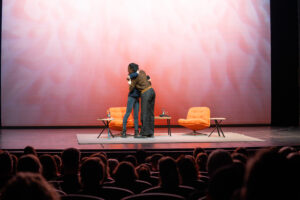 Anna Dushime und Gilda Sahebi umarmend auf der Bühne. 
