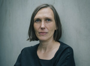 Foto der Regisseurin vor grauer Wand