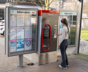 Mädchen bezahlt mit Karte an Ticketautomat.