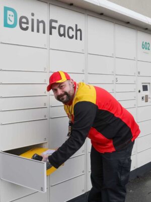 Paketzusteller holt Pakete aus dem Automaten
