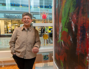 Frau mit Brille steht vor einem Bild