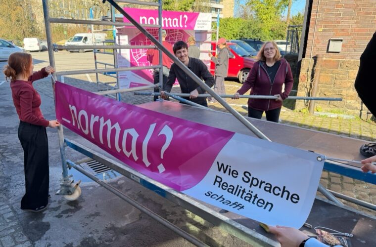 Studierende befestigen Transparente an Gerüsten