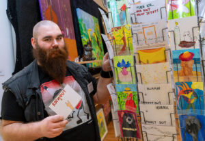 Mann mit Bart präsentiert die Arbeiten aus Lindenhorst.