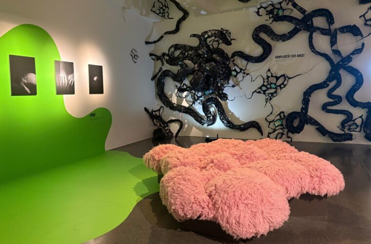 Ausstellungsraum mit Fotografien rechts und großer Installation links.