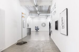 Blick in einen Gang, an den Wänden hängen Fotografien