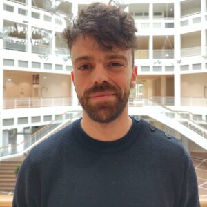 Paul guckt direkt in die Kamera - im Hintergrund das Innere des Rathauses Dortmund