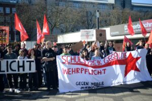 Schüler:innen halten das Banner "Schulstreik gegen die Wehrpflicht" hoch