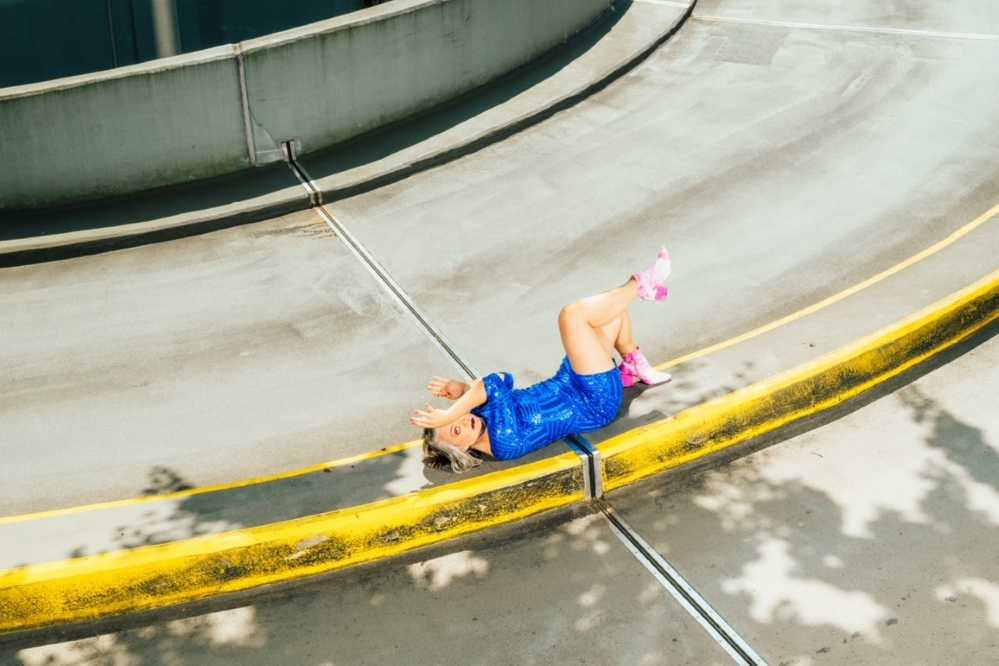 Person posiert auf dem Mittelstreifen einer Straße