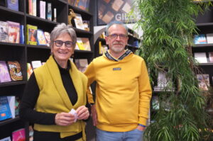 Mann und Frau stehen vor Bücherregalen