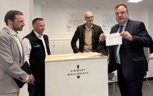 Norbert Dahmen hält einen Stimmzettel hoch.