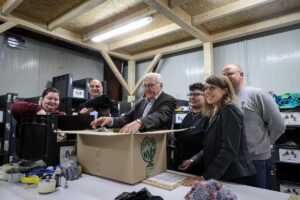 Beteiligte packen Karton mit Kleidung