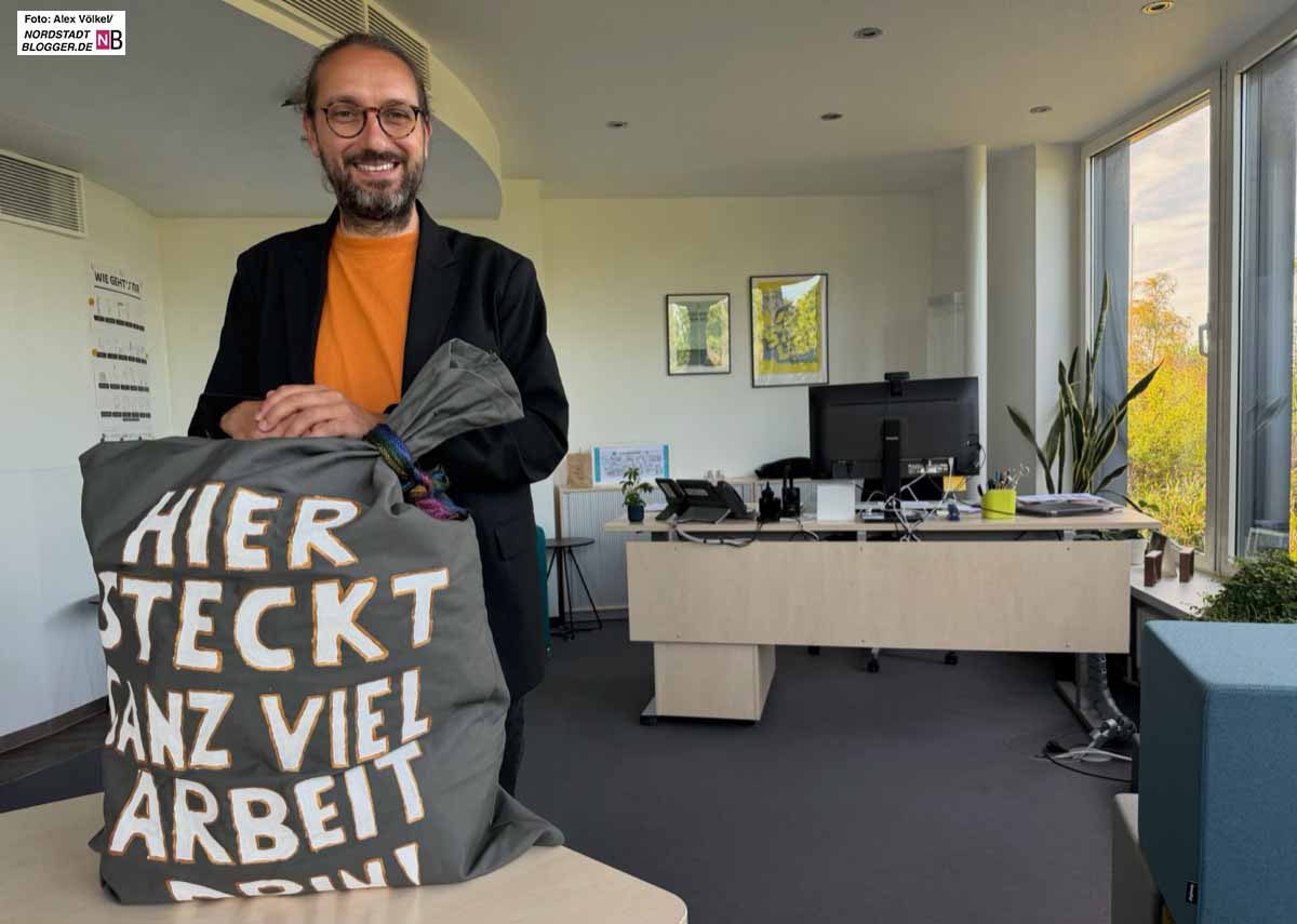 Vor ihm steht ein Sack mit der Aufschrift: Hier steckt ganz viel Arbeit drin!
