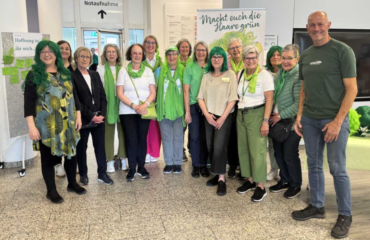 Gruppenbild Personal und Patient:innen mit grünen Haaren