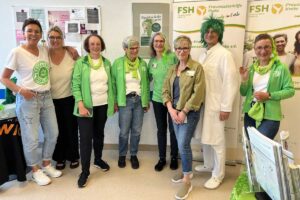 Gruppenbild Personal und Patient:innen mit grünen Haaren