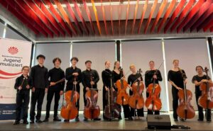 Teilnehmende posieren mit Instrumenten für Gruppenbild