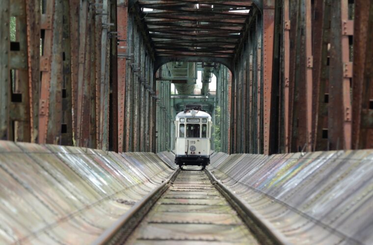 Blick auf die Brücke mit einer alten Bahn auf Schienen.