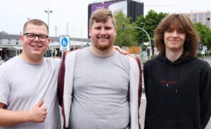 Auf dem Bild sieht man ein Foto der drei Männer die in die Kamera lächeln.