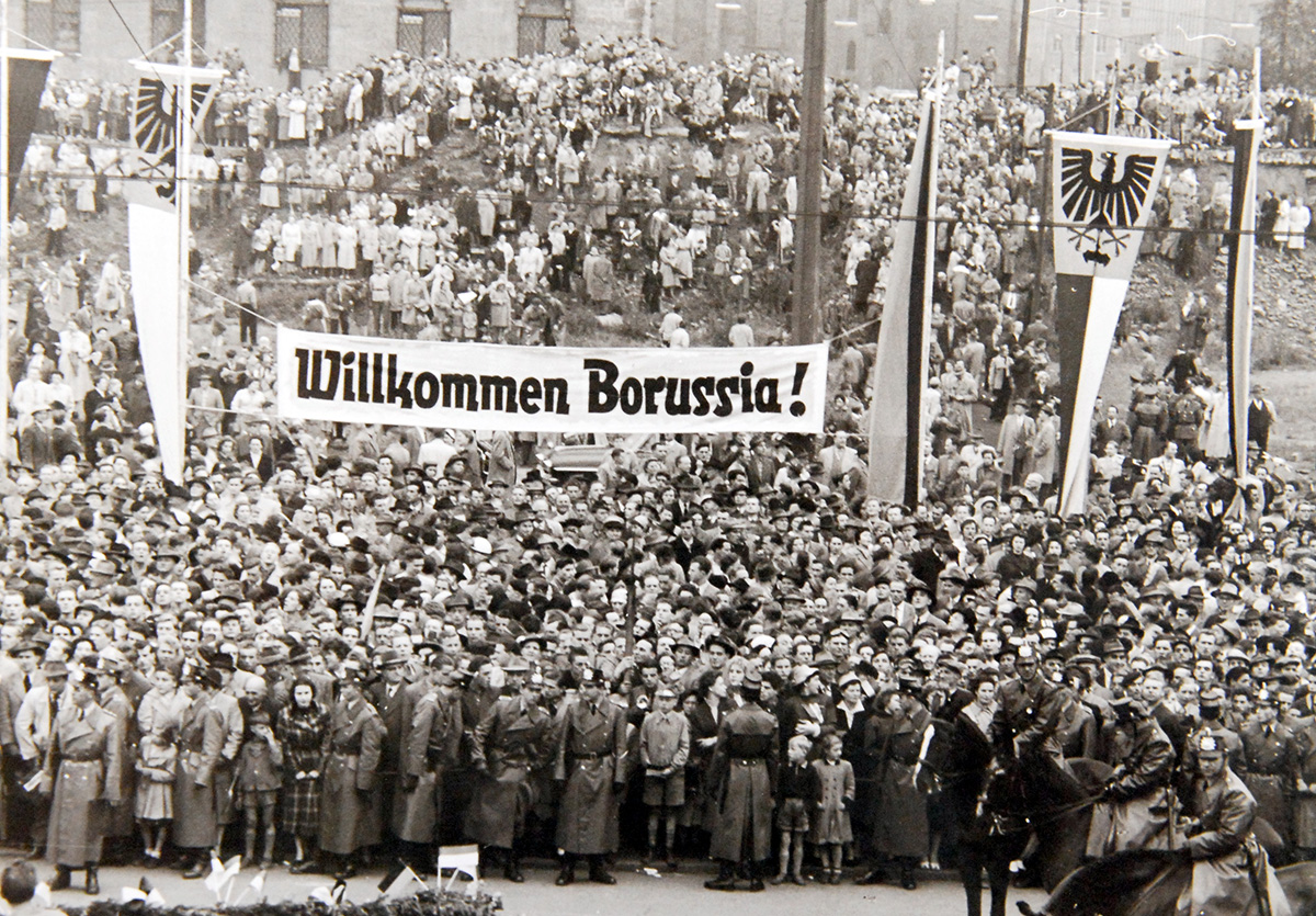 Tausende Menschen mit einem „Willkommen Borussia“-Banner.