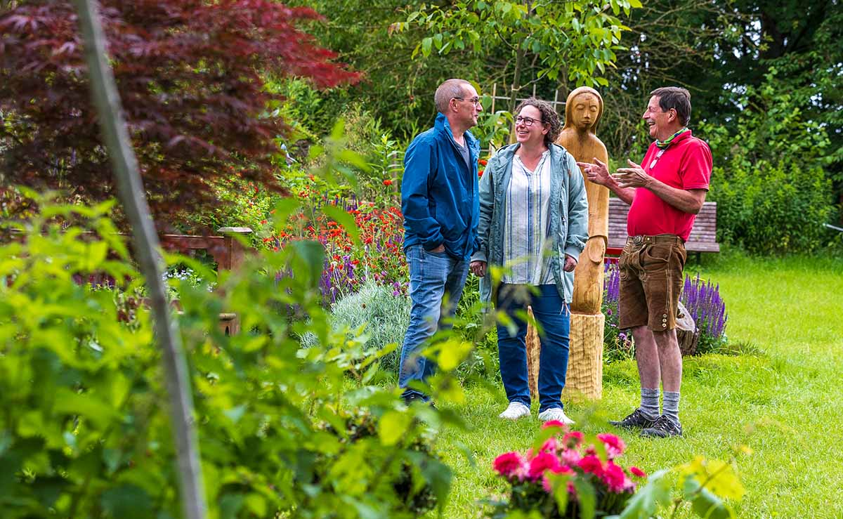 Blick in einen Garten mit Kunstwerk im Hintergrund
