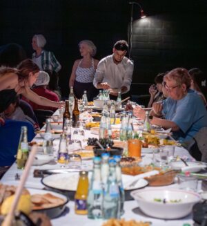 Menschen an einem Tisch mit Essen und Getränken