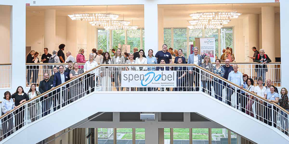 Menschen stellen sich auf der großen Treppe im Rathaus zum Gruppenfoto auf
