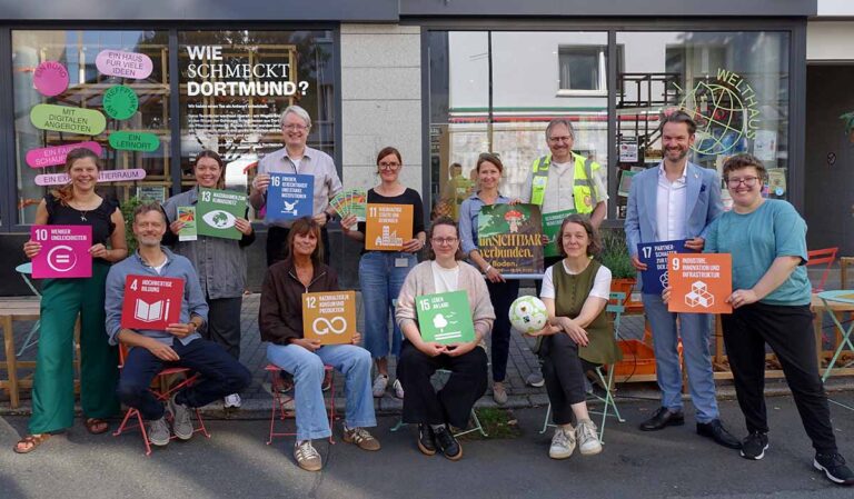 Gruppenbild mit Menschen. Sie präsentieren die Nachhaltigkeitsziele.
