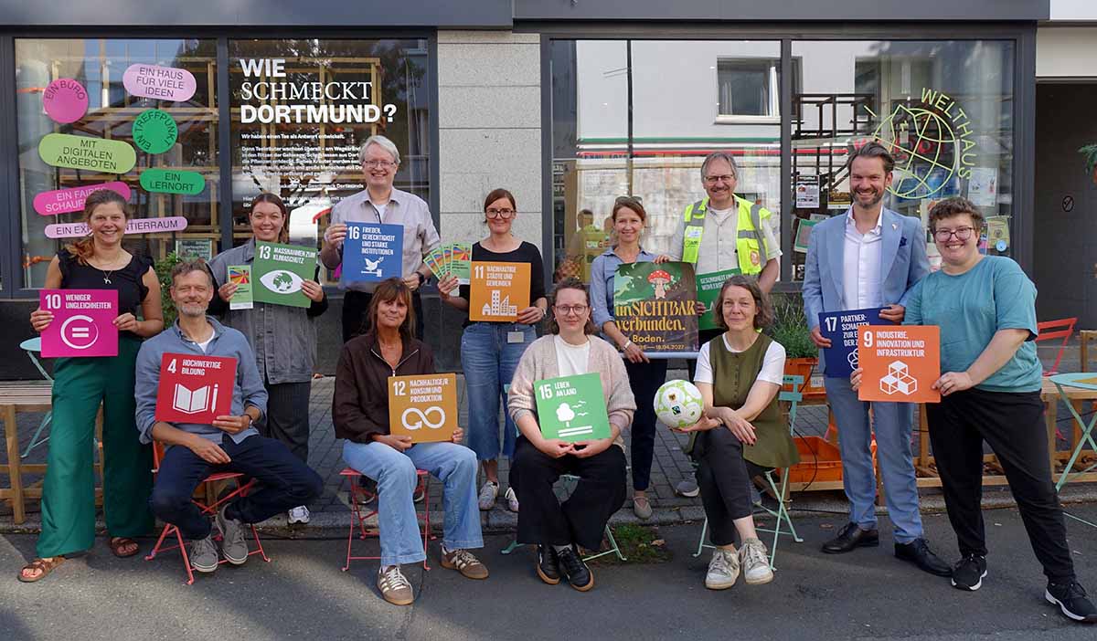 Gruppenbild mit Menschen. Sie präsentieren die Nachhaltigkeitsziele.
