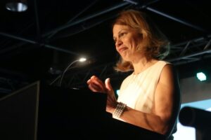 Eine Frau applaudiert an einem Rednerpult