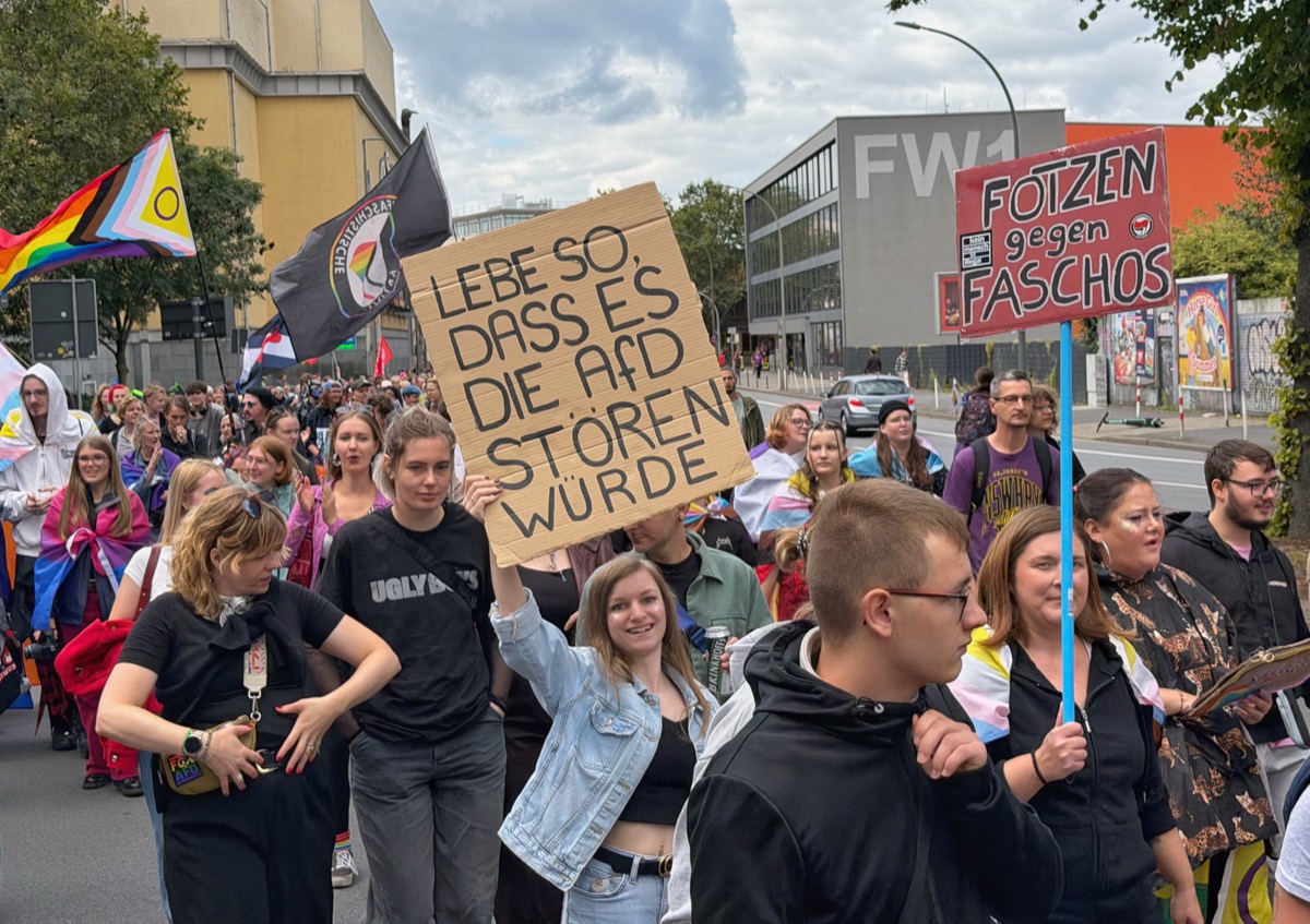 Demonstrant:innen halten Schilder in die Höhe.