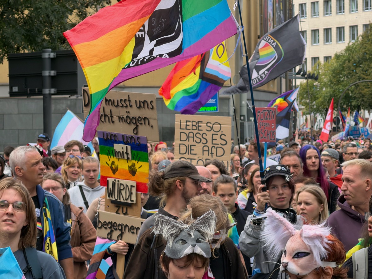 Bunte Fahnen wehen über Menschenmengen