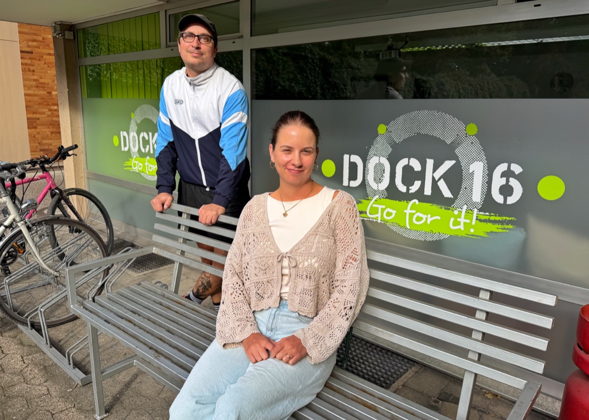 Zwei Personen vor einem Schaufenster mit Logo