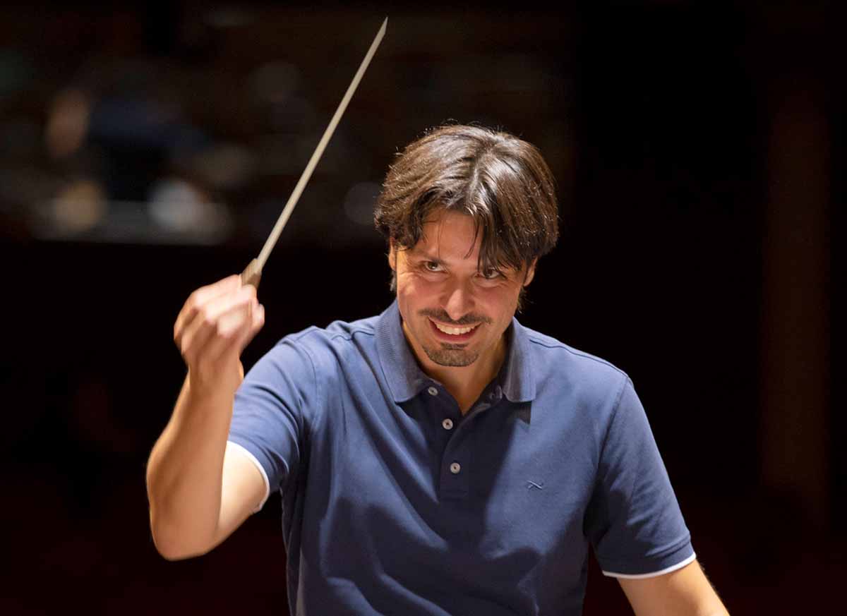 Der Dirgent steht vor einem Orchester