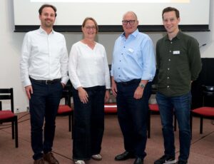 Drei Männer und eine Frau posieren für ein Foto.
