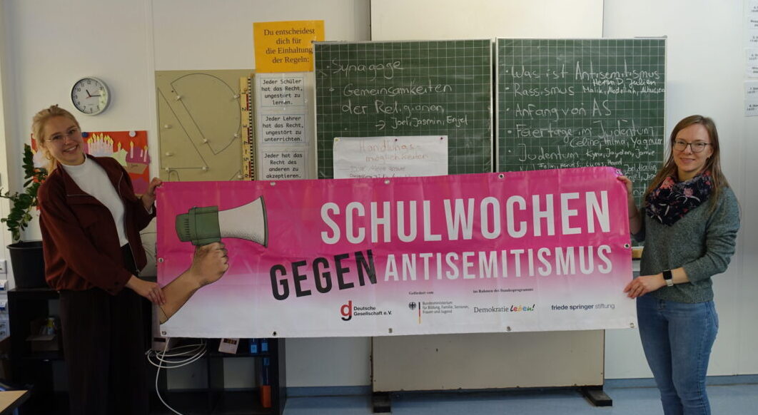 Zwei Frauen, die ein Banner halten.