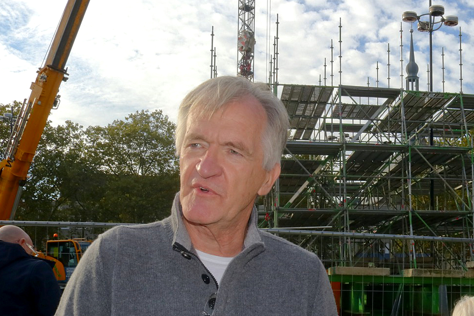 Mann im Vordergrund , Baugerüst dahinter
