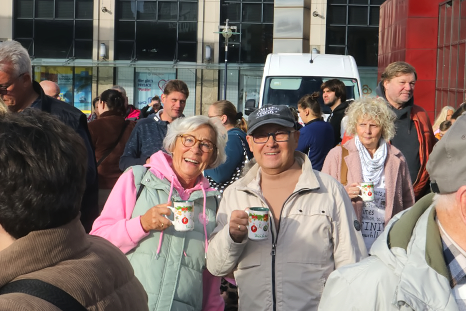 Zwei Senioren mit Glühwein Tassen in den Händen