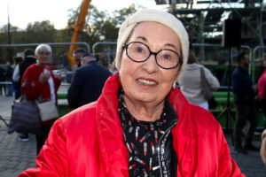 Portrait einer ältere Dame mit Brille und roter Jacke