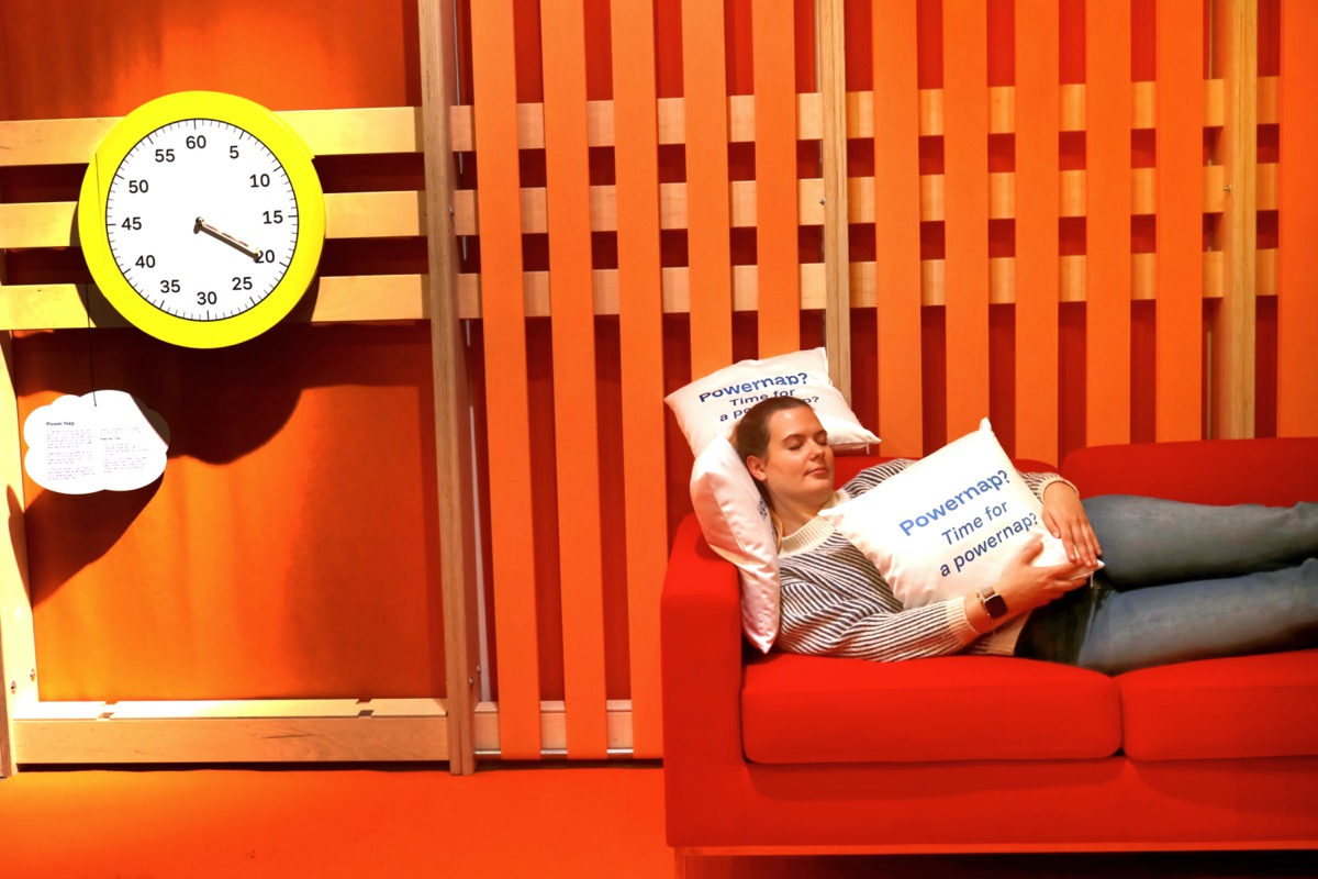 Schlafende Person auf einem Sofa mit einem Kissen im Arm