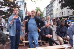 Die Moderatorin lässt einen Zuhörer ins Mikrofon sprechen.