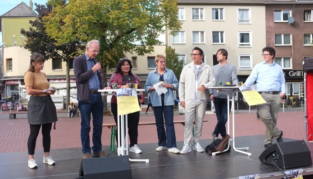 Sechs Menschen stehen nebeneinander auf einer Bühne