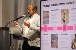 Gestikulierender Mann an einem Rednerpult